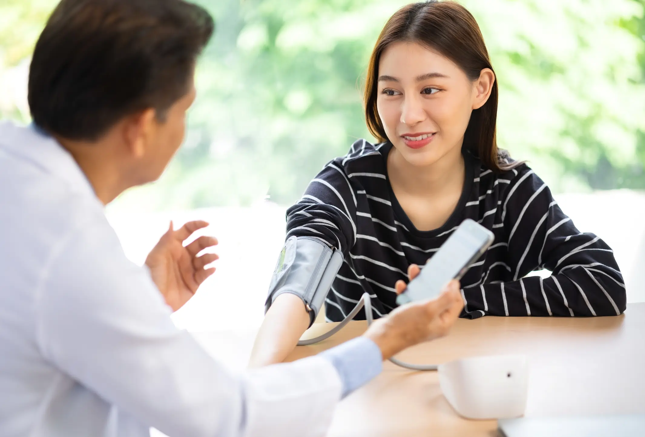 Infirmier prenant la pression d'une cliente